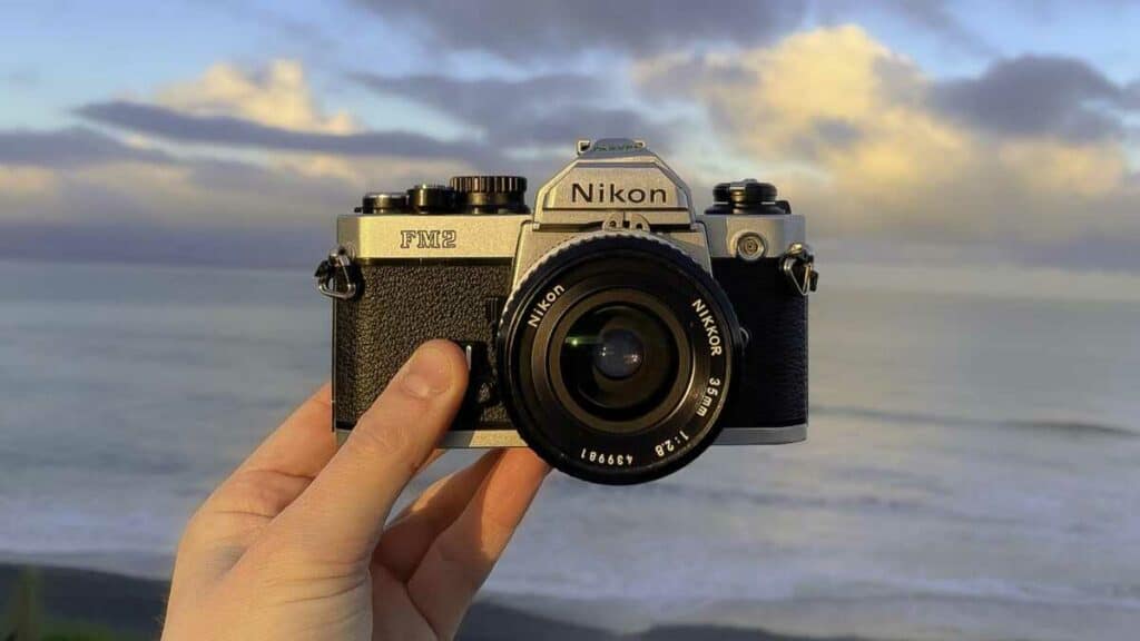 picture of someone holding a nikon fm2n camera
